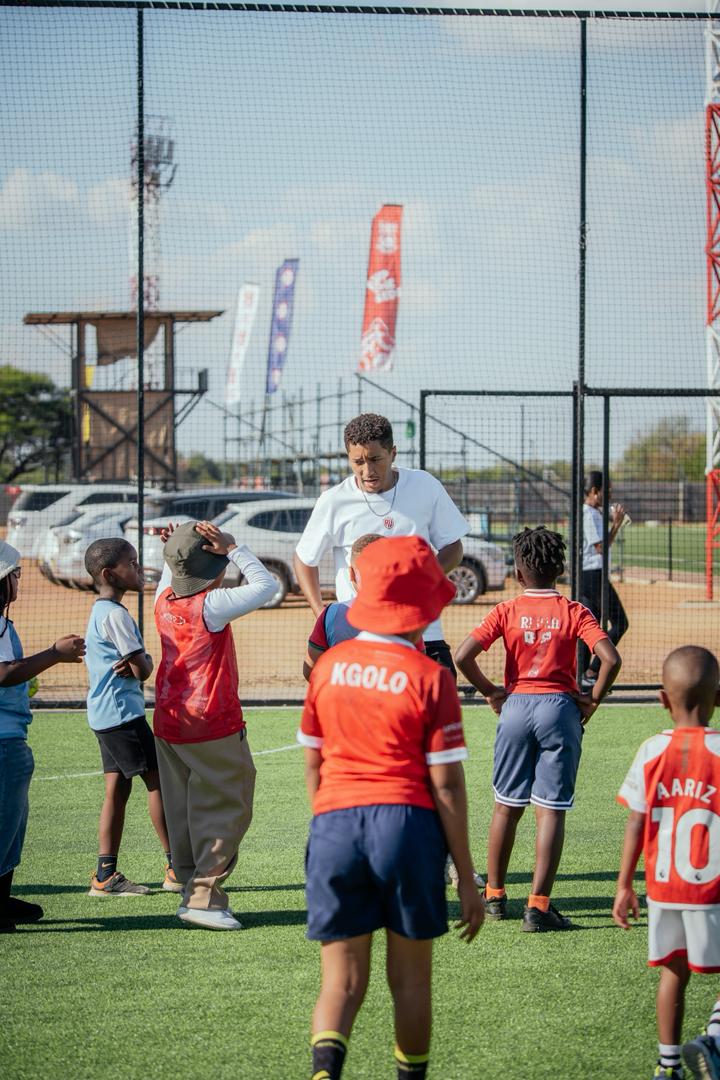 Young Real United players gathering around their coach as one academy family
