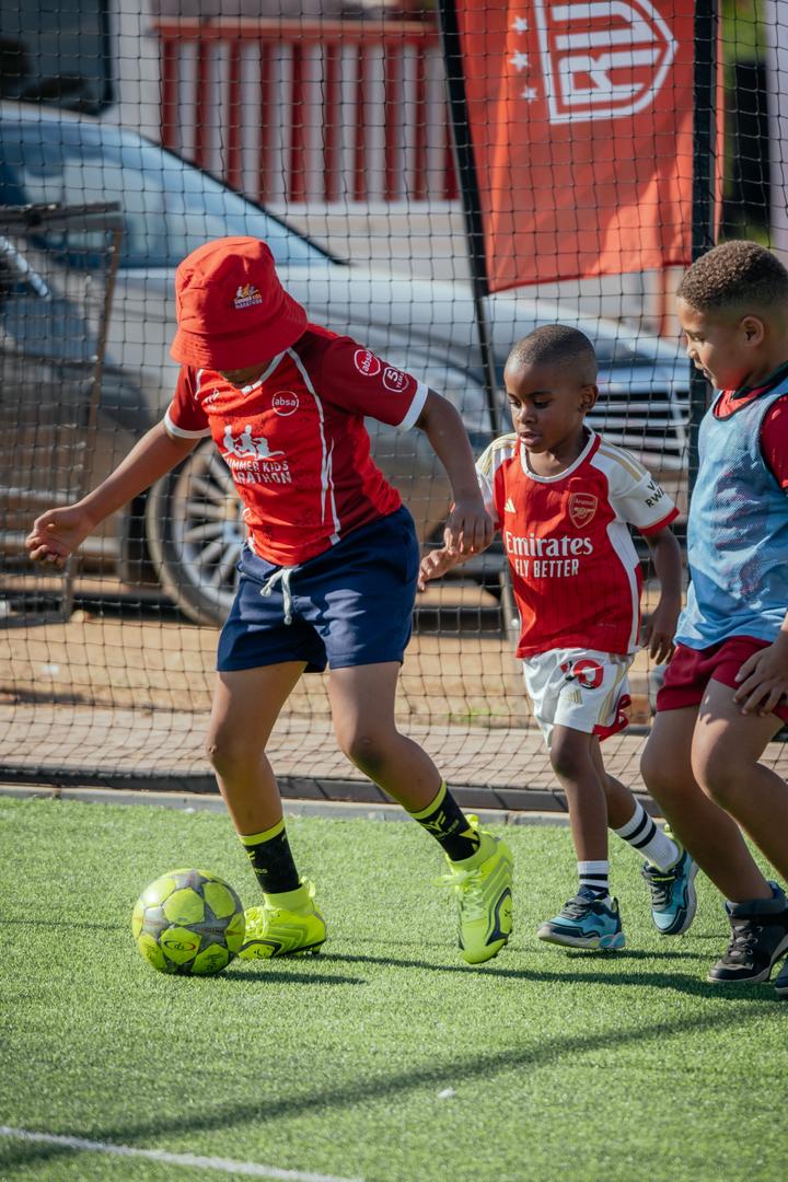 Young Real United players playing football together on the pitch